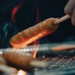 a person is holding a hot dog